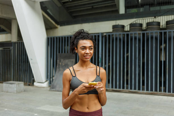 istock Young sportswoman looks at smartphone resting at training 1347681357