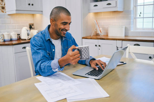 istock Shot of a young man using a laptop and having coffee  working at home 1347682328