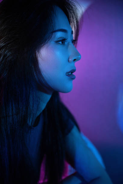 istock Beautiful woman in grey dress under neon light 1347682573