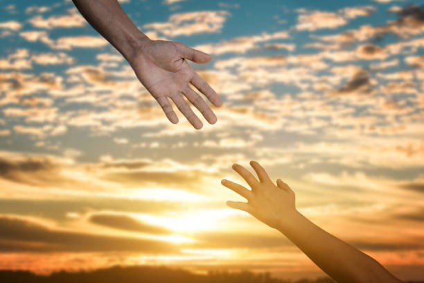 istock Reaching hand helping, hope and support each other over sunset 1347684003