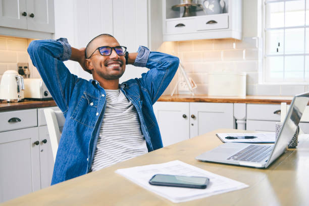 foto de un joven tomando un descanso mientras trabajaba en casa - businessman happiness carefree computer fotografías e imágenes de stock