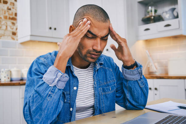 istock Shot of a young man using a laptop and looking stressed while working at home 1347684261