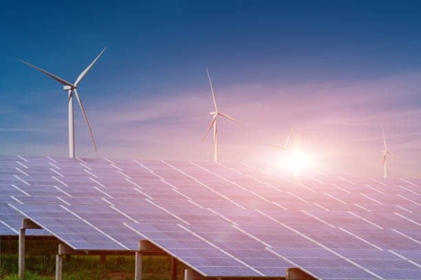 istock Solar panel with wind turbine against sunset sky background 1347684570