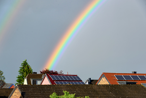 Double rainbow over the roofs of residential buildings