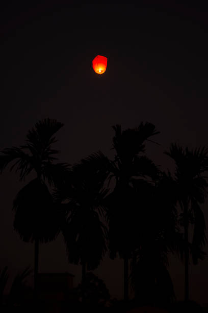 una linterna del cielo que va al cielo en la noche de diwali - paper lantern flash fotografías e imágenes de stock