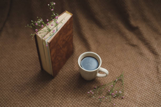 istock A book and cup of coffee on dark background 1347688604