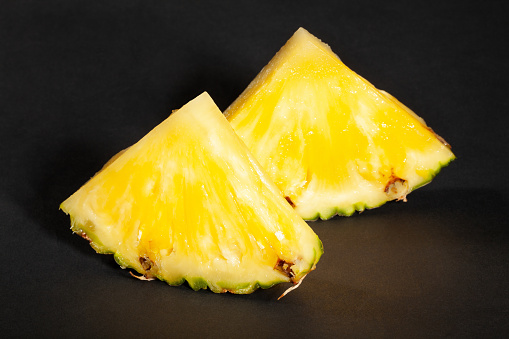 sliced pineapple on black background