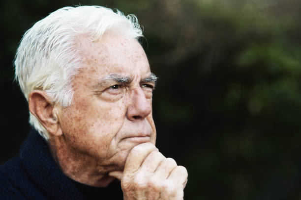 istock White-haired old man lost in deep thought, hand on chin, perhaps planning something 1347690671