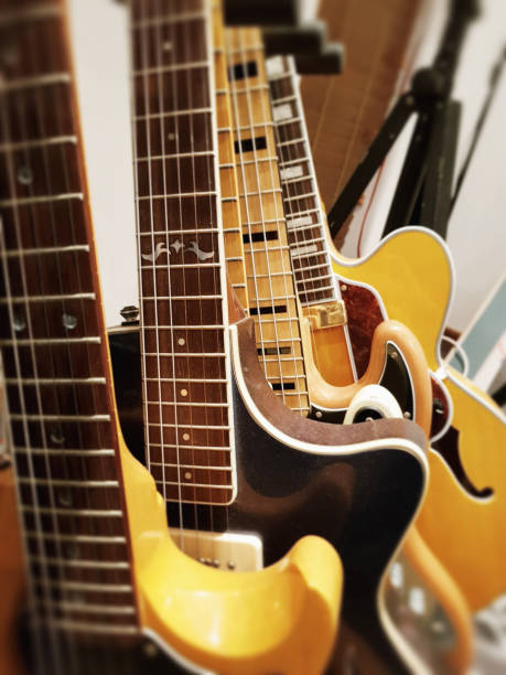 Five electric guitars standing in a rack