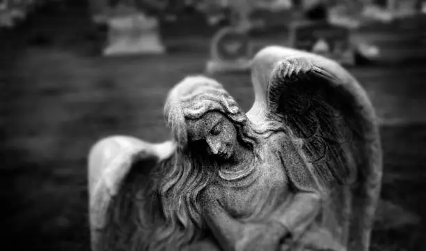 Photo of Gravestone grave stone headstone in cemetery angel statue grief and remembrance wings and prayer
