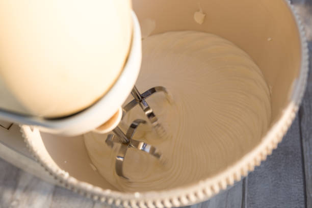 istock Step-by-step process of making a sour cream chocolate cake. Sour cream preparation. Sour cream is whipped with a mixer with sugar. 1347695440
