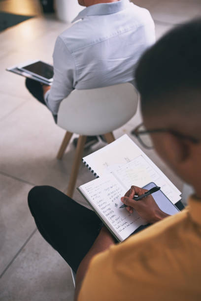 istock Shot of an unrecognizable businessperson writing in a notebook during a conference at work 1347695672