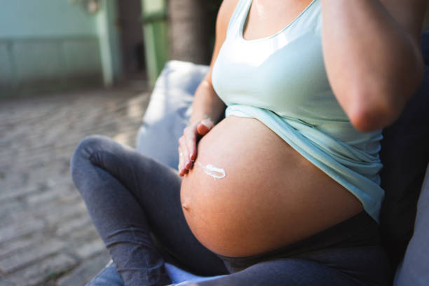 istock Applying moisturizer on pregnant belly 1347698325