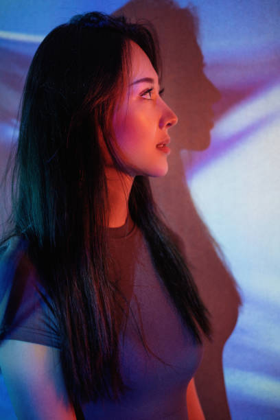 istock Beautiful woman in grey dress under neon light 1347700239
