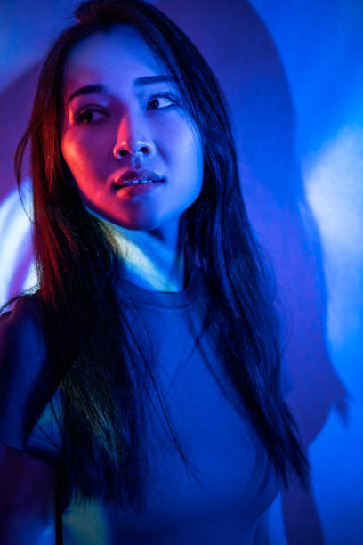 istock Beautiful woman in grey dress under neon light 1347700290