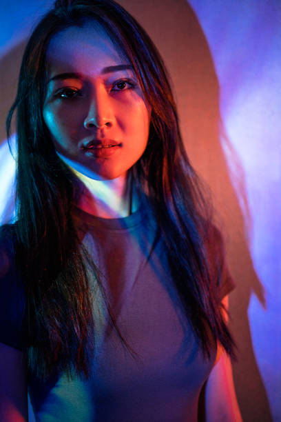 istock Beautiful woman in grey dress under neon light 1347700292