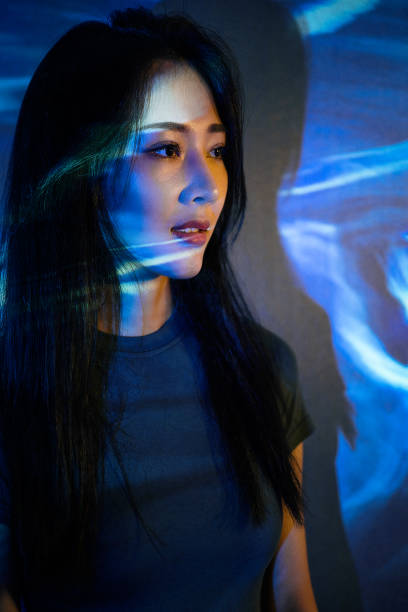 istock Beautiful woman in grey dress under neon light 1347700308
