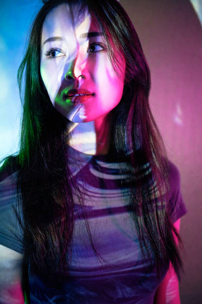 istock Beautiful woman in grey dress under neon light 1347700410