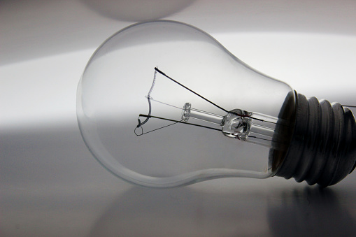 New light bulb in front of white background and covered with a paper - side view