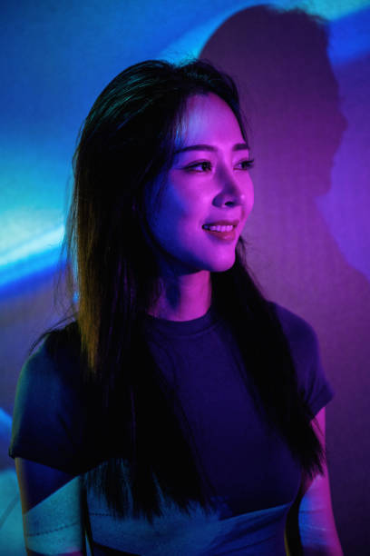 istock Beautiful woman in grey dress under neon light 1347700631