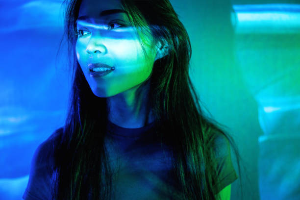 istock Beautiful woman in grey dress under neon light 1347701252