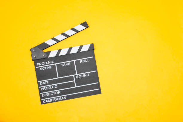 istock movie clapper on yellow background, cinema concept 1347703040