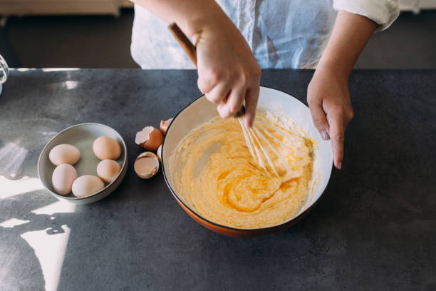 istock Anonymous Plus Size Female Baker Mixing Dough with a Whisk in a Domestic Kitchen 1347703409
