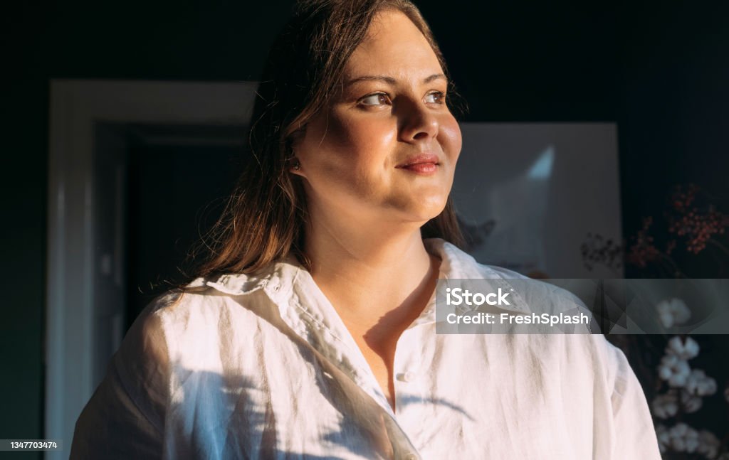 Portrait of a Proud Plus Size Pastry Chef Looking Away A portrait of a beautiful Caucasian overweight female baker looking away Obesity Stock Photo