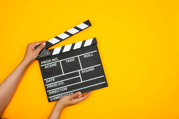 istock movie clapper on yellow background, cinema concept 1347703599
