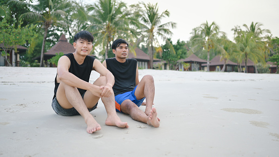 Portrait of young asian couple LGBTQ having good moment with friend on beach sunset in south east asia