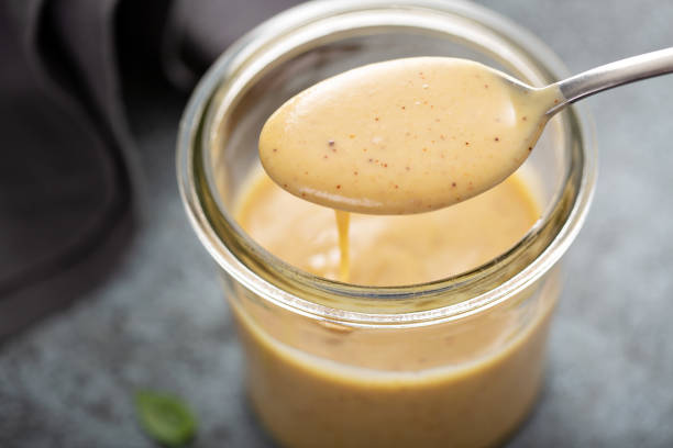 Homemade honey mustard sauce in a glass jar Homemade creamy honey mustard sauce in a glass jar mustard stock pictures, royalty-free photos & images