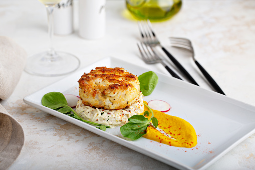 Gourmet plated fishcake or crabcake with vegetable puree, restaurant food
