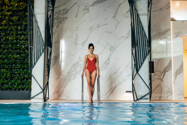 istock Beautiful Woman Getting Into a Swimming Pool 1347703999