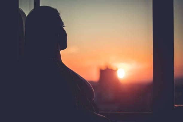 istock Woman in silhouette at window 1347704727