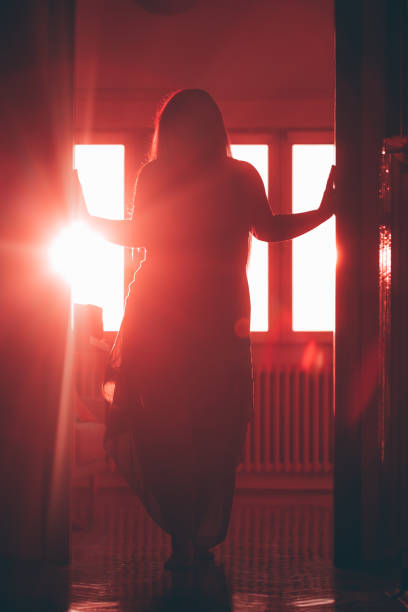 istock Woman in silhouette at door 1347704813