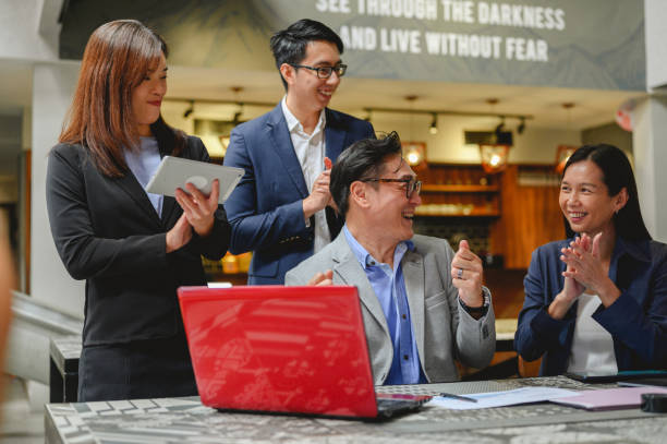 istock Group of Asian businesspeople clapping hands while meeting for success in open working space 1347705143