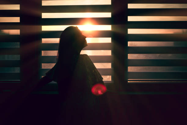 istock Woman in silhouette at window 1347706349