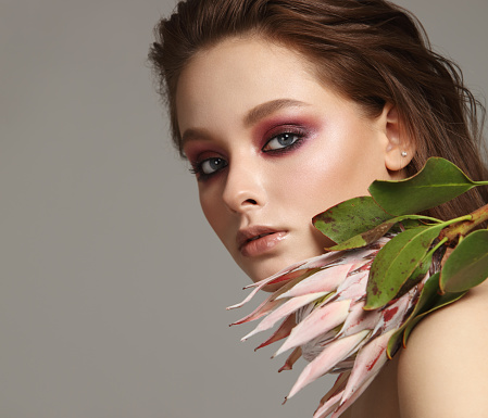 Portrait of beautiful fresh girl with protea flower