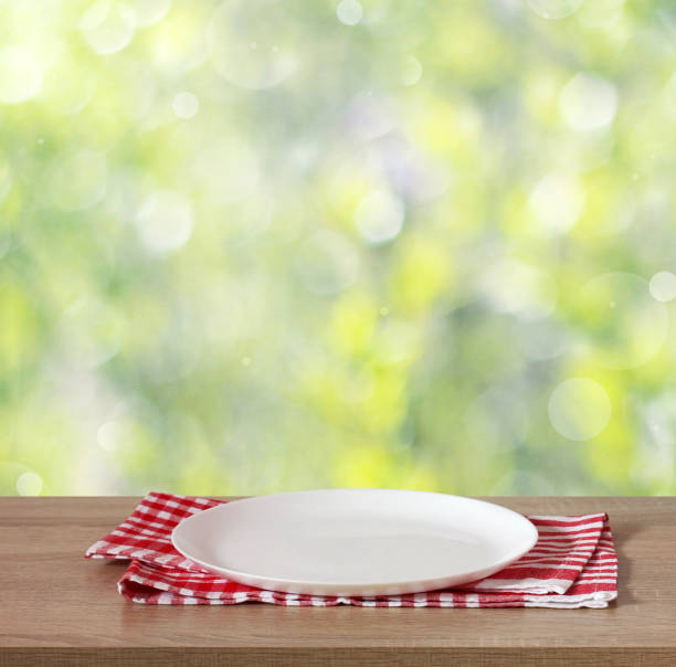 istock table with an empty plate on a blurred green natural background 1347710144