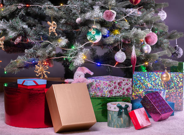istock Boxes of presents under decorated artificial Christmas tree. 1347713814