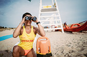 istock Female lifeguard with life buoy and binoculars 1347714386