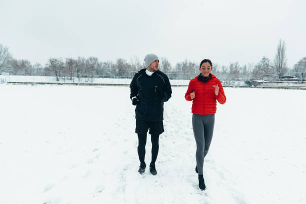 istock Young couple going for a run together during a snow 1347714398