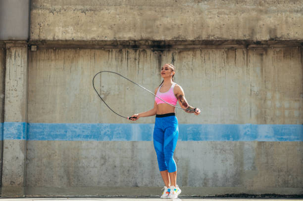 istock Attractive young woman using a fitness jump rope while training outside 1347714414