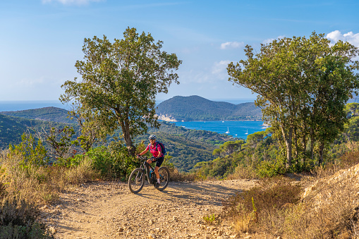 A group of middle-aged African-American men wearing lycra cycling clothes enjoying a morning ride on a sunny day in the Santa Monica Mountains in Malibu, California.  They stop by a roadside vista point to enjoy the view.