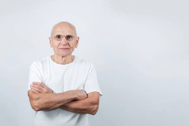 istock Senior man with folded arms and wearing eyeglasses on grey background 1347716872