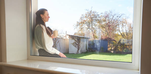 istock Woman relaxing in her backyard next to a window while drinking coffee 1347717176