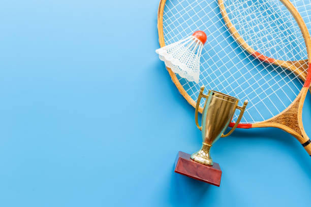 istock Small golden trophy cup with rackets and shuttlecock for winner, top view 1347717177