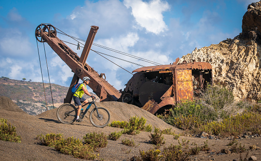 nice active woman riding her electric mountain bike in the abandoned Iron Ore mines of Calamite peninsula on the Island of Elba, Tuscan Archipelago, Tuscany,Italy