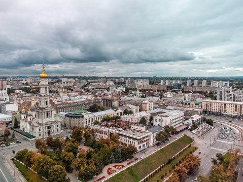 Autumn city aerial view, Dormition Cathedral, Pavlivska Square and downtown streets with gray heavy clouds in Kharkiv, Ukraine