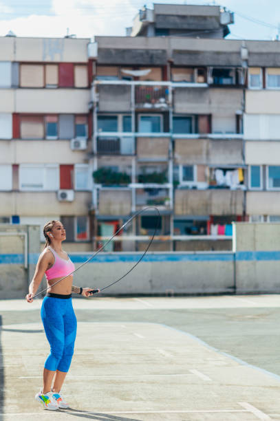 istock Attractive young woman using a fitness jump rope while training outside 1347725036